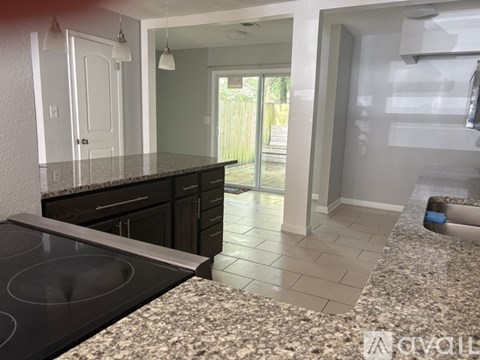A kitchen with granite countertops and a stove top oven.