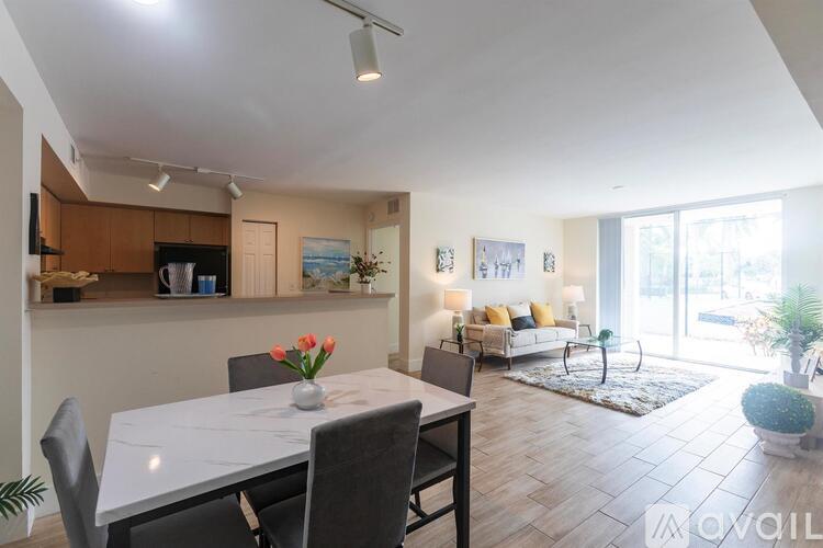 A modern dining room with a white table and grey chairs.