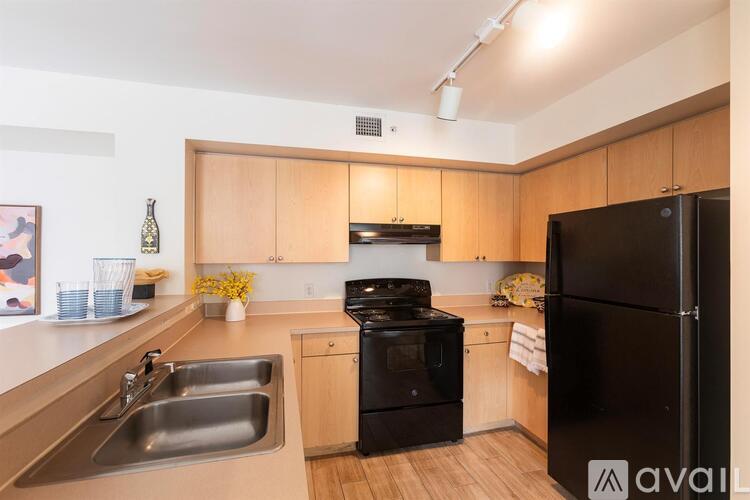 A kitchen with wooden cabinets and a black refrigerator.