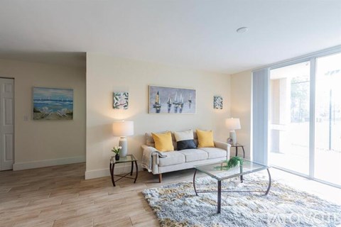 A living room with a couch, two lamps, and a painting on the wall.