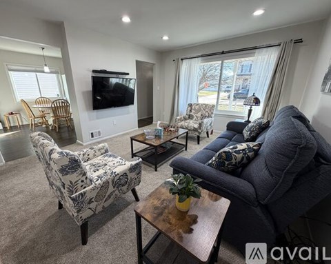 A living room with a grey couch, a coffee table, and a television.