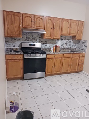 A kitchen with wooden cabinets and a black stove top oven.
