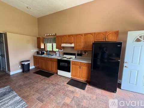 A kitchen with wooden cabinets and black appliances.