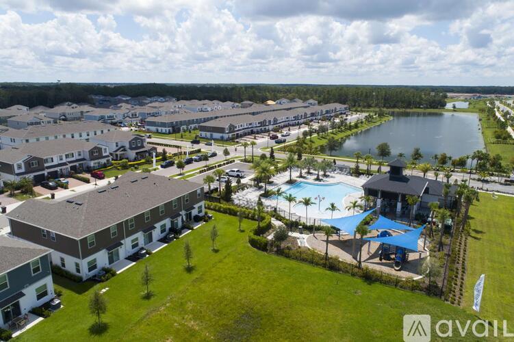 A bird's eye view of a resort with a swimming pool and a lake in the background.