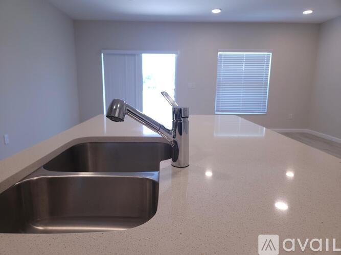 A modern kitchen with a stainless steel sink and granite countertop.