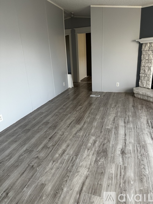 A room with wooden flooring and white walls.
