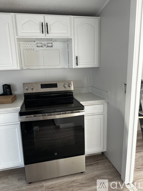 A modern kitchen with white cabinets and a stainless steel oven.