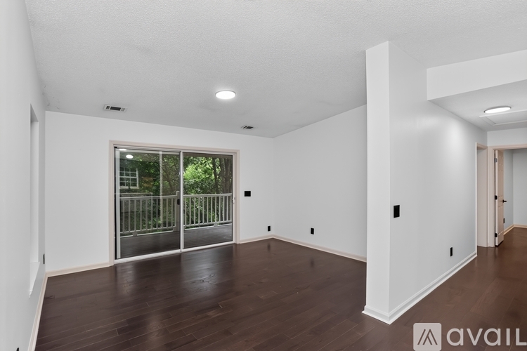 A spacious room with wooden floors and white walls.