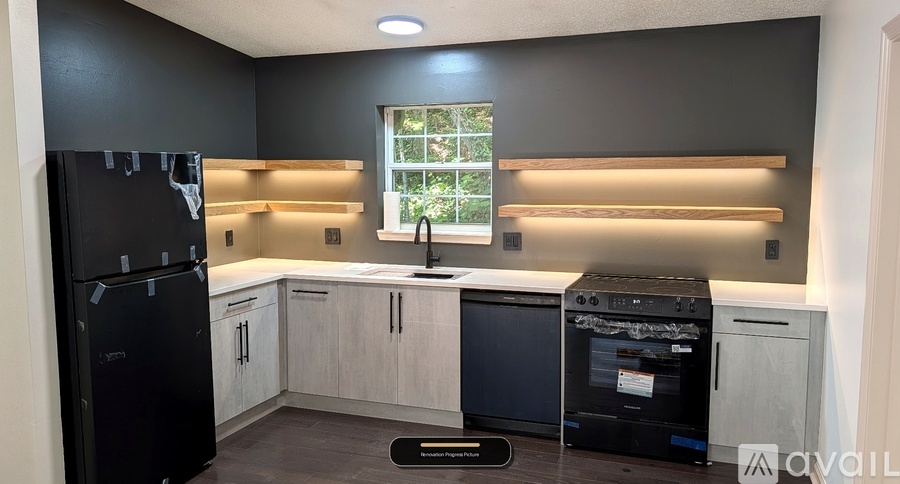 A kitchen with black appliances and white cabinets.