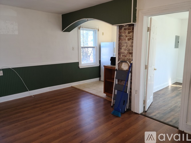 A room with a wooden floor and a green wall.