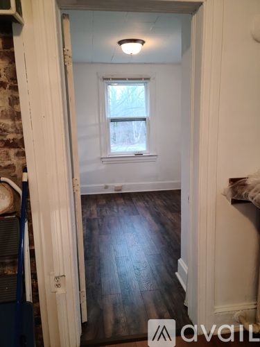 A room with a window and wooden floors.