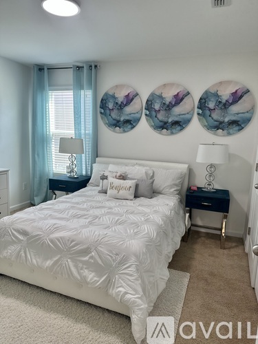A bedroom with a large bed and two lamps.