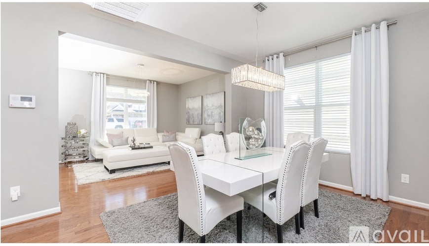 A modern dining room with a white table and chairs.