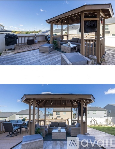 A wooden gazebo with a table and chairs on a deck.