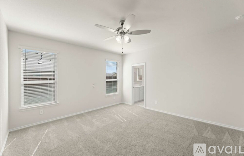 A spacious room with a ceiling fan and carpeted floor.
