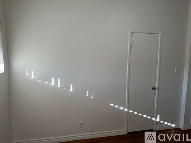 A room with a white door and a wall with a row of lights on it.