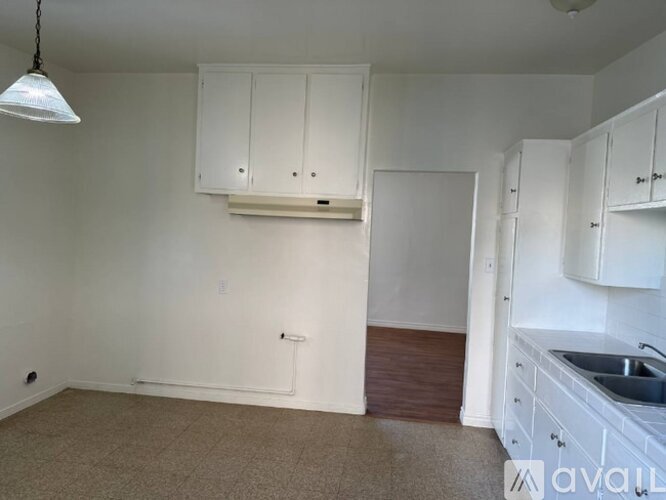 A kitchen area with white cabinets and a sink.