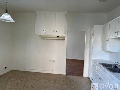 A kitchen area with white cabinets and a sink.