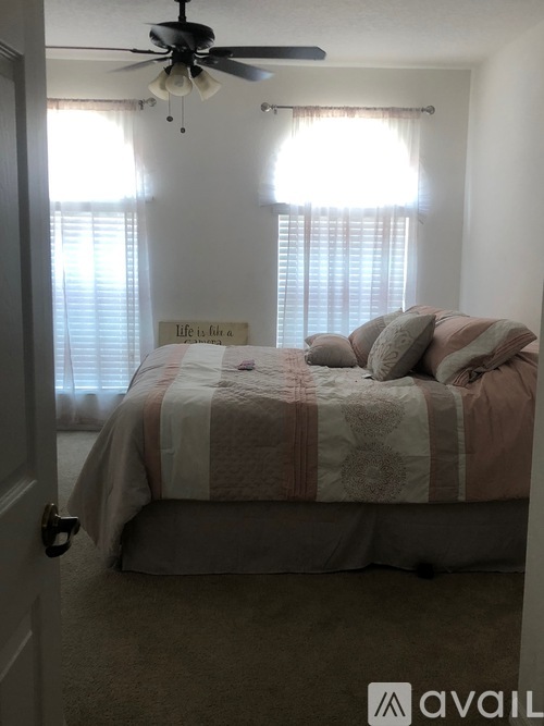 A bedroom with a bed and a ceiling fan.