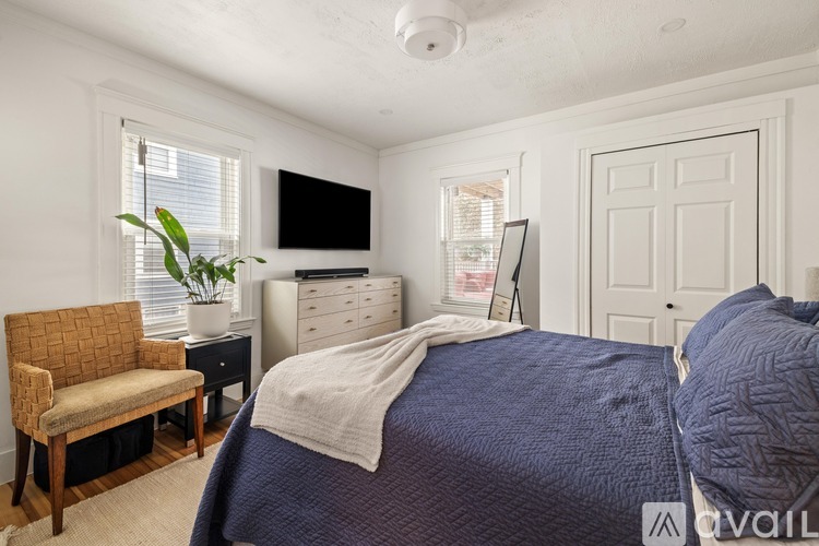 A bedroom with a large bed and a chair.