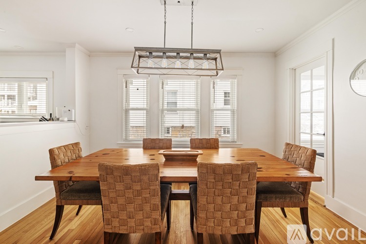 A dining room with a wooden table and chairs.