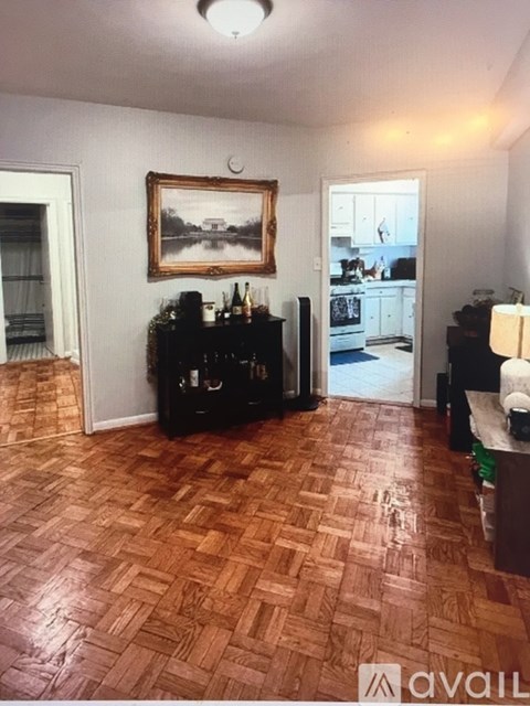A living room with a wooden floor and a painting hanging on the wall.