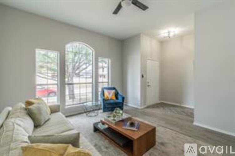 A living room with a couch, a coffee table, and a ceiling fan.