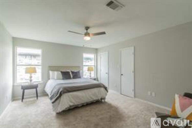 A bedroom with a large bed and a ceiling fan.