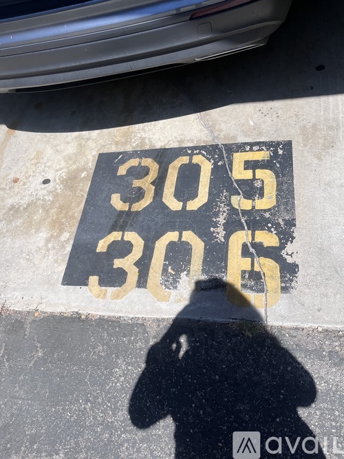 A shadow of a person is cast on a wall with the numbers 30.5 and 30.6 painted on it.