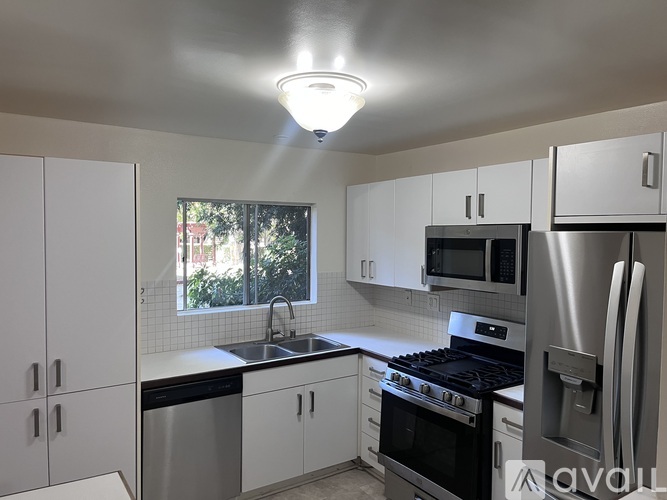 A kitchen with white cabinets and stainless steel appliances.