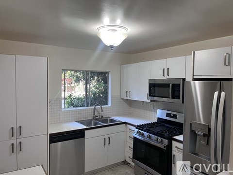 A kitchen with white cabinets and stainless steel appliances.