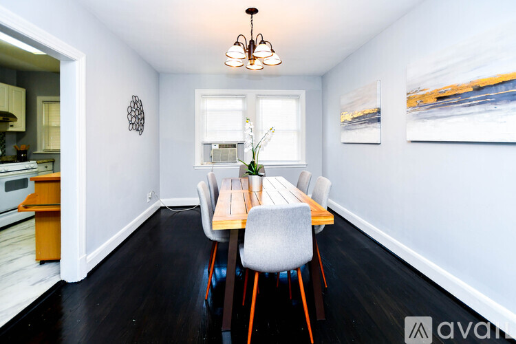 A dining room with a wooden table and chairs.