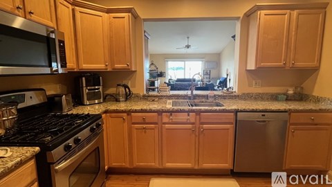 A kitchen with wooden cabinets and granite countertops.