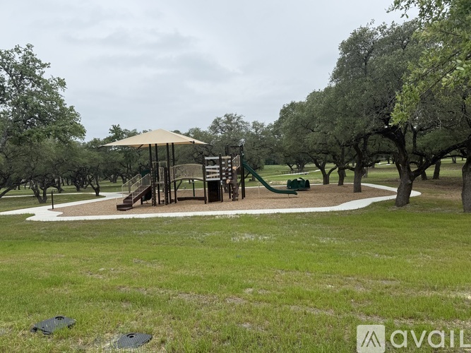 A playground with a slide and a swing set in a grassy area.