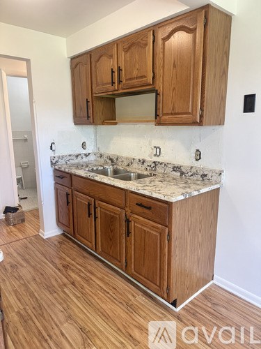 A kitchen with wooden cabinets and a granite countertop.