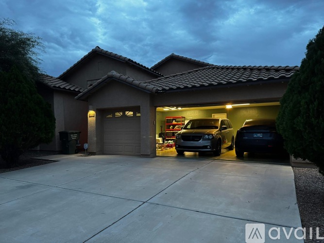 A house with a garage and two cars parked inside.