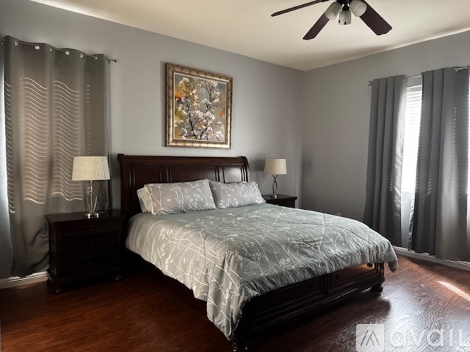 A bedroom with a large bed and a ceiling fan.