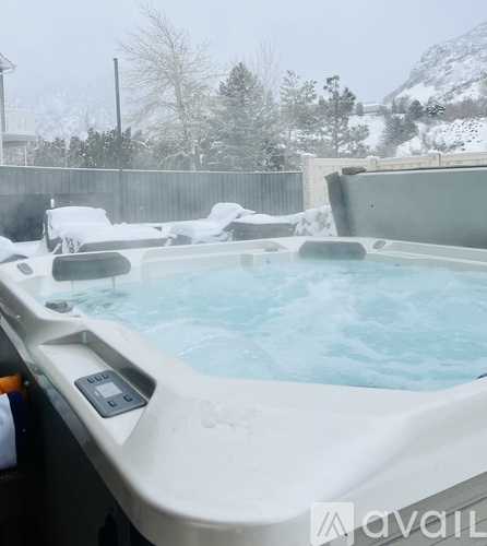 A hot tub in a backyard covered in snow.