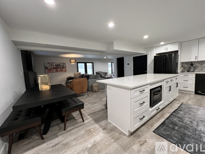 A modern kitchen with white cabinets and a black countertop.