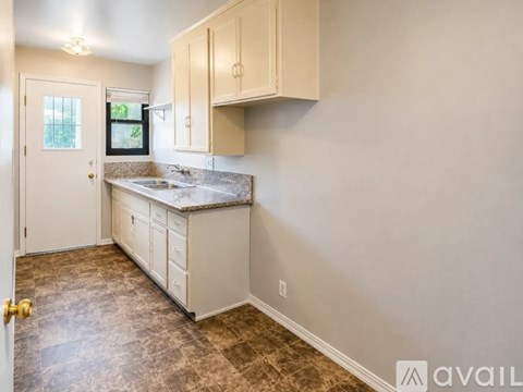 A kitchen with white cabinets and a granite countertop.
