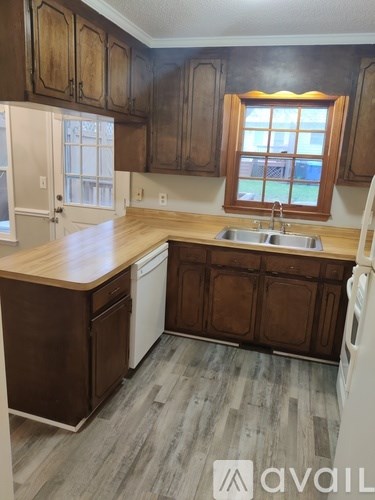 A kitchen with wooden cabinets and a white dishwasher.
