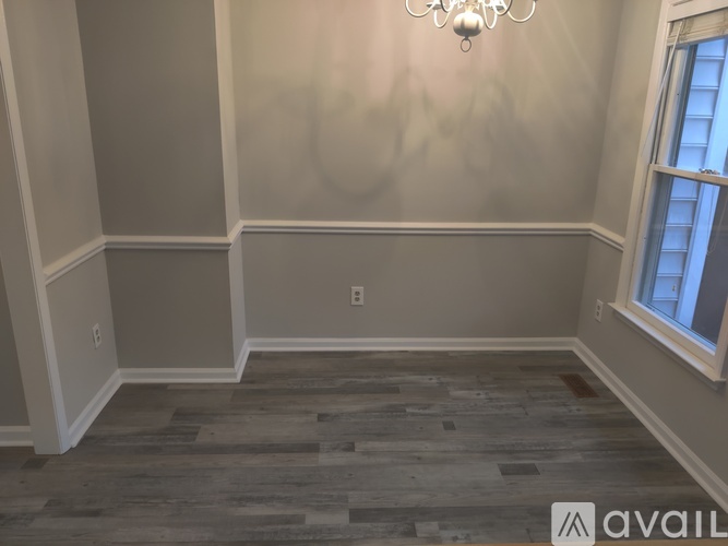 A room with wooden flooring and a window.