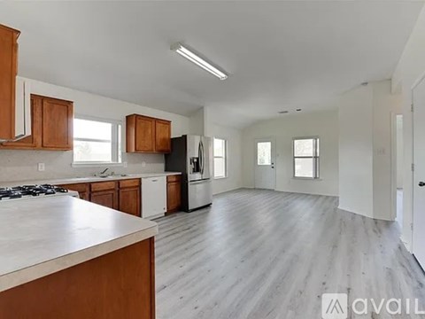 A kitchen with wooden cabinets and a white countertop is available for rent.