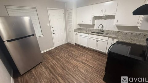 A kitchen with a refrigerator, sink, and cabinets.