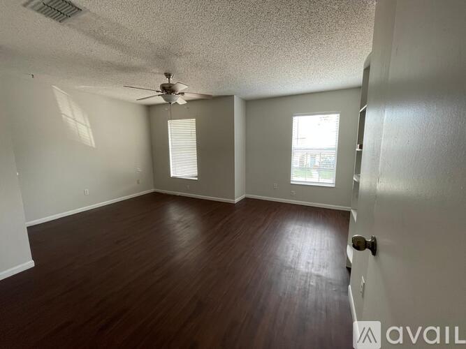 A room with wooden floors and a ceiling fan.