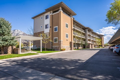 A large apartment complex with a parking lot in front.