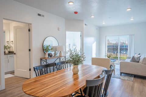 A modern dining room with a wooden table and chairs.