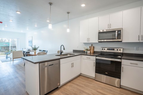 A modern kitchen with white cabinets and stainless steel appliances.