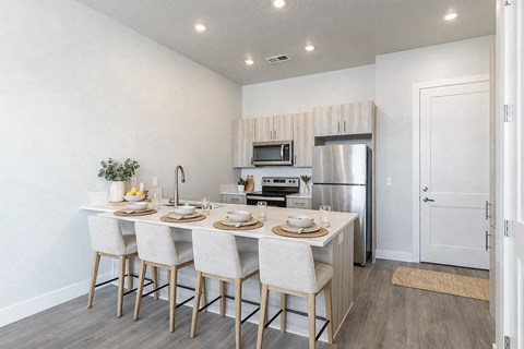 A modern kitchen with a dining table set for four.