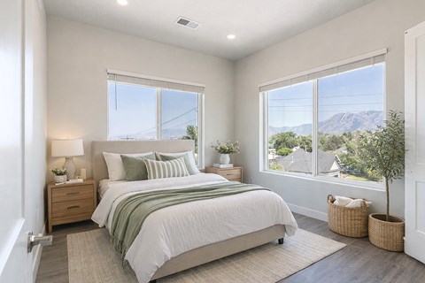 A bedroom with a large bed and a view of the mountains outside the window.